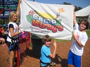 three kids holding a camp mirage flag