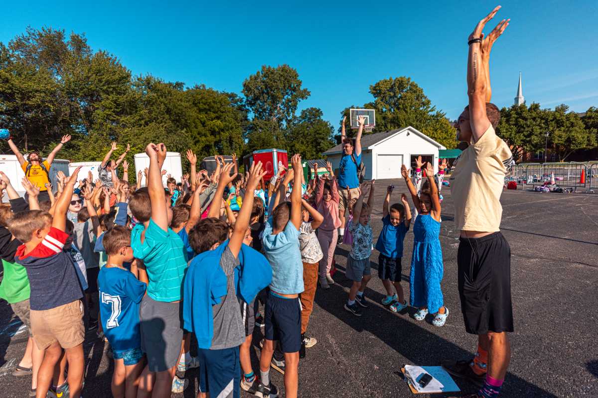 group of campers at bonfire meeting doing morning stretch