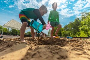 boys playing in the sand box at camp mirage beach party